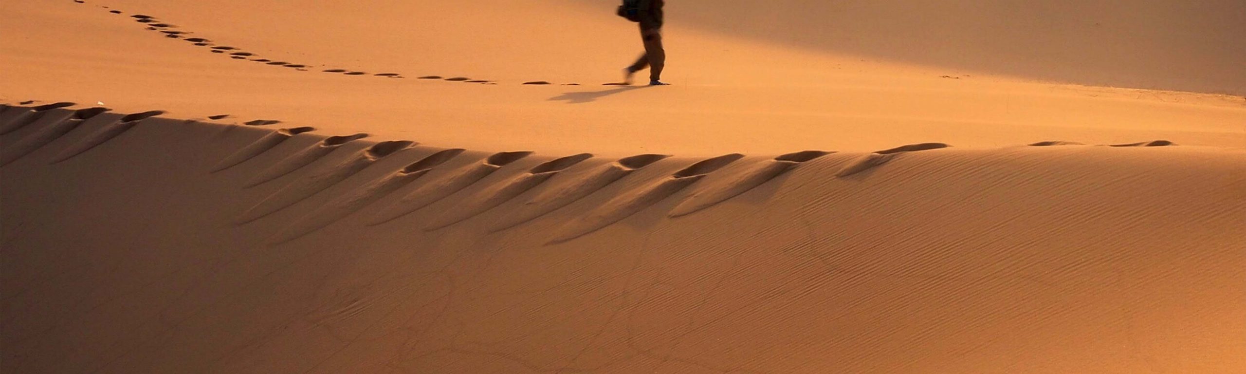 uomo che cammina nel deserto